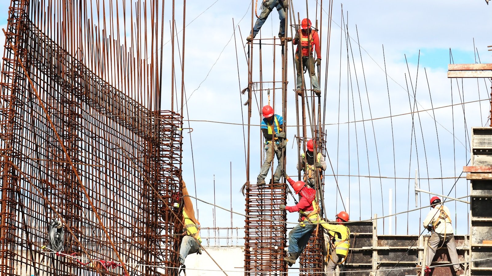 Equipes trabalhando na armação dos pilares de uma obra de estrutura de concreto